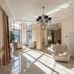 Modern house exterior wall paint colour combination in Vizag with cream, white and grey shades.